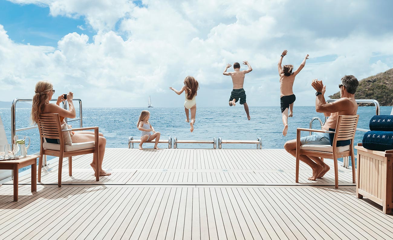 Family jumping off the back of a superyacht